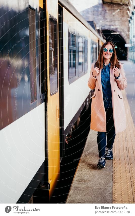 happy young woman walking at train station. Travel concept screen destination travel backpack caucasian europe railway waiting track wagon arrival long urban