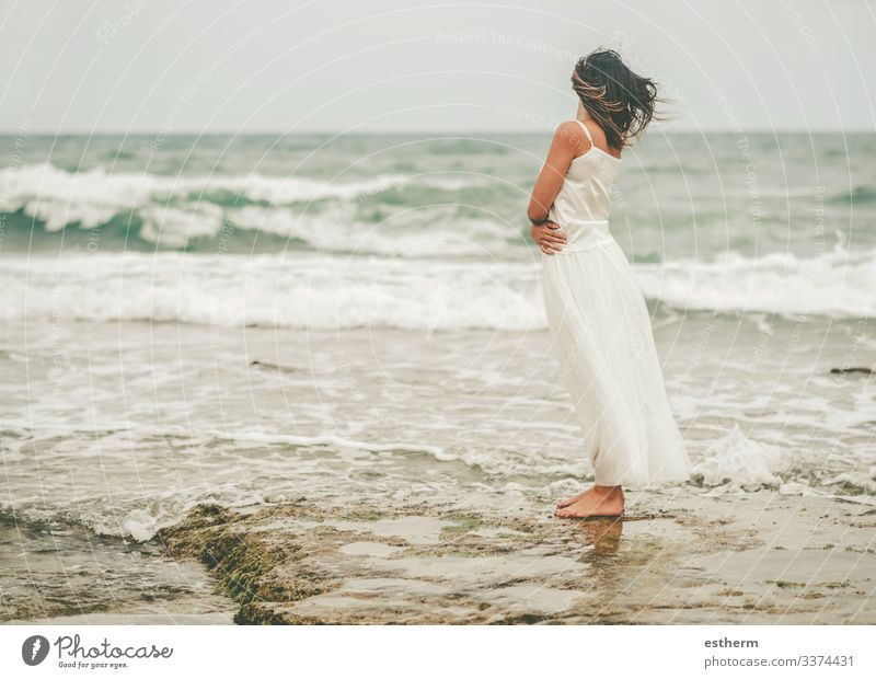 Back view of Pensive Young woman on the beach young woman beautiful elegant elegance dream dreaming dreams dress fashion freedom fun glamor independence joy