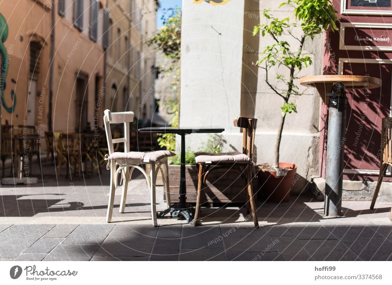 two old different wooden chairs with small table in front of a bistro in the streets of Marseille Sunlight Beautiful weather Warmth Tree