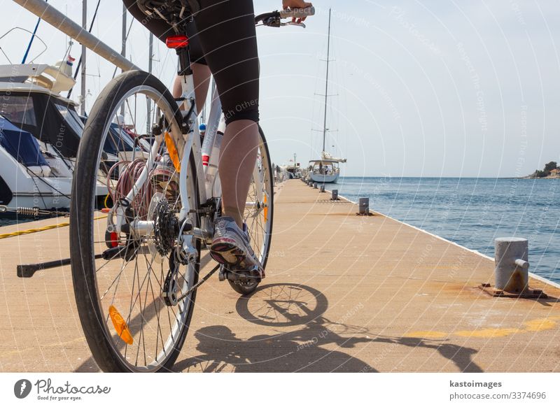 Detail of woman riding a bike in marina in Rovinj, Istria, Croatia, Adriatic sea. ride biking cycling exercise lifestyle sport cyclist bicycle leisure travel