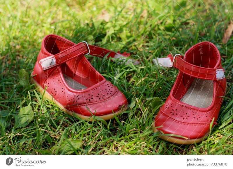 Red children's shoes in the grass Footwear ballerinas summer shoes open Velcro move out Summer Grass Green Complementary colours Barefoot Meadow Joy Lawn