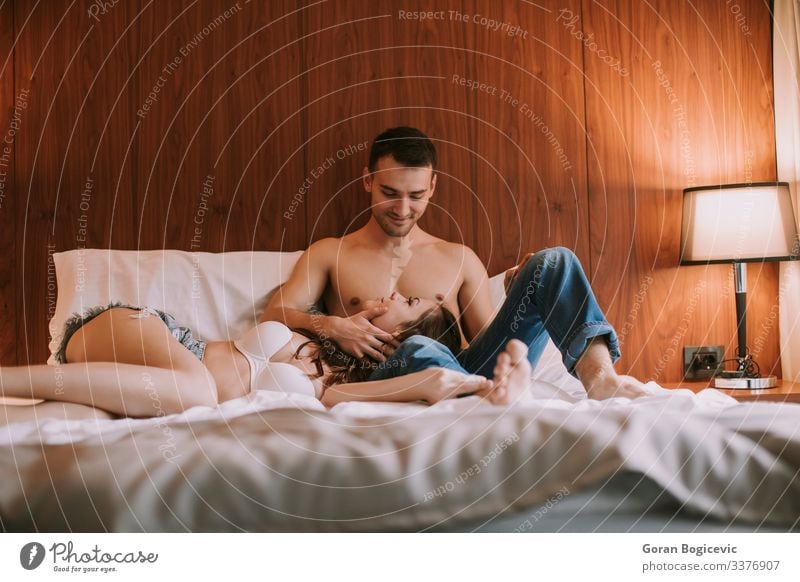 Young happy couple in love lying on bed and enjoying each other Joy Happy Relaxation Bedroom Human being Young woman Youth (Young adults) Young man Woman Adults