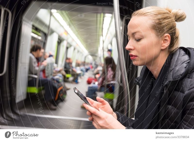 Young girl reading from mobile phone screen in metro. Lifestyle Vacation & Travel Trip Decoration Business Telephone Cellphone PDA Screen Human being Woman