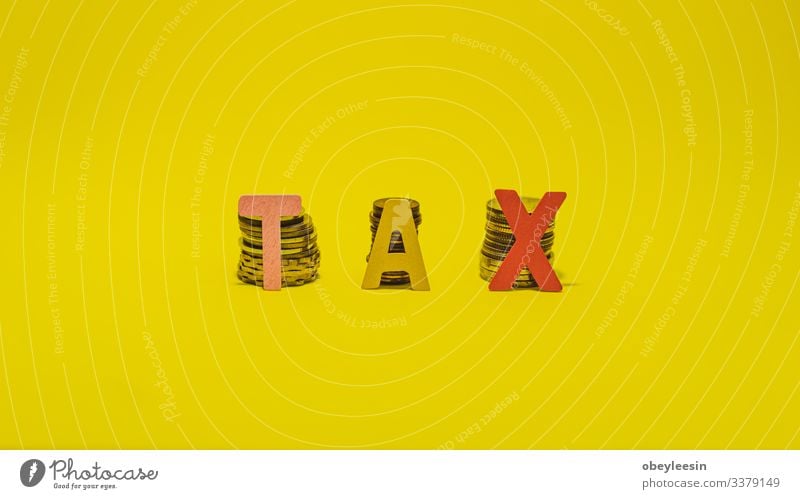 Tax Concept with wooden block on stacked coins Lifestyle Money Desk Table Success Work and employment Profession Office work Workplace Economy