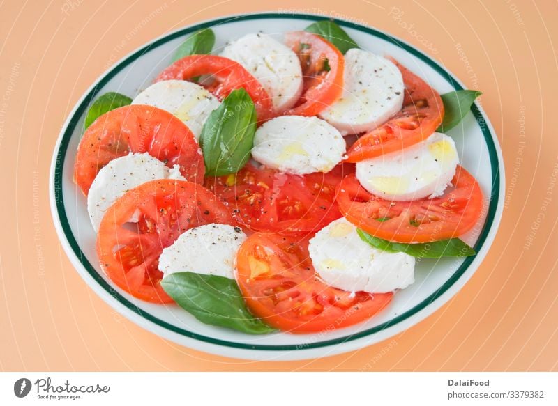 Caprese salad in brown background Cheese Vegetable Herbs and spices Nutrition Eating Diet Plate Table Fresh Red White Tradition Basil caprese salad Cooking food