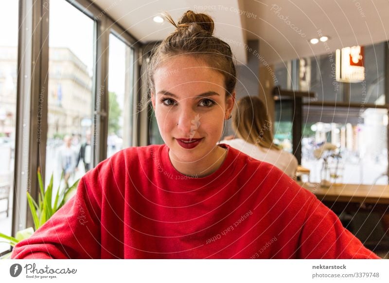 Young Caucasian Woman Smiling at Camera Inside Coffee Shop Smile female girl woman young adult youth culture day female beauty beautiful woman natural beauty