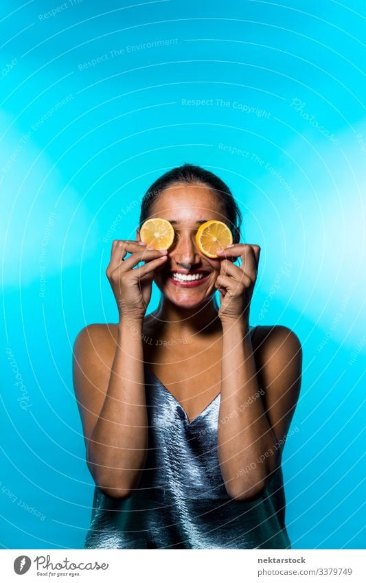 Young Woman Holding Lemon Slices on Eyes slice female girl eyes holding up concept minimalism citrus fruit fresh freshness smile happiness conceptual sky blue