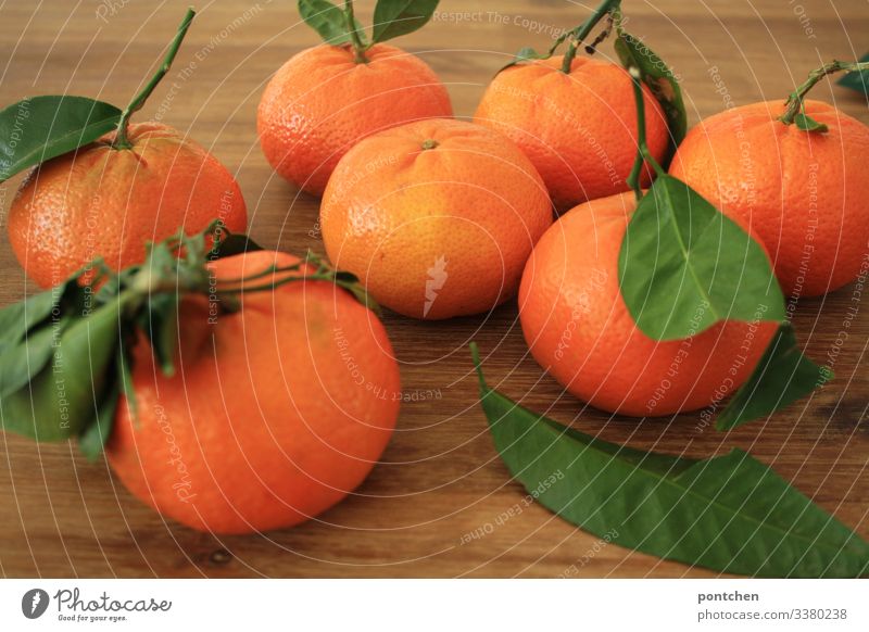 Seven mandarins with green leaves lying on a wooden table Food Fruit Nutrition Organic produce Diet Sour Orange Tangerine Leaf Table Healthy Healthy Eating