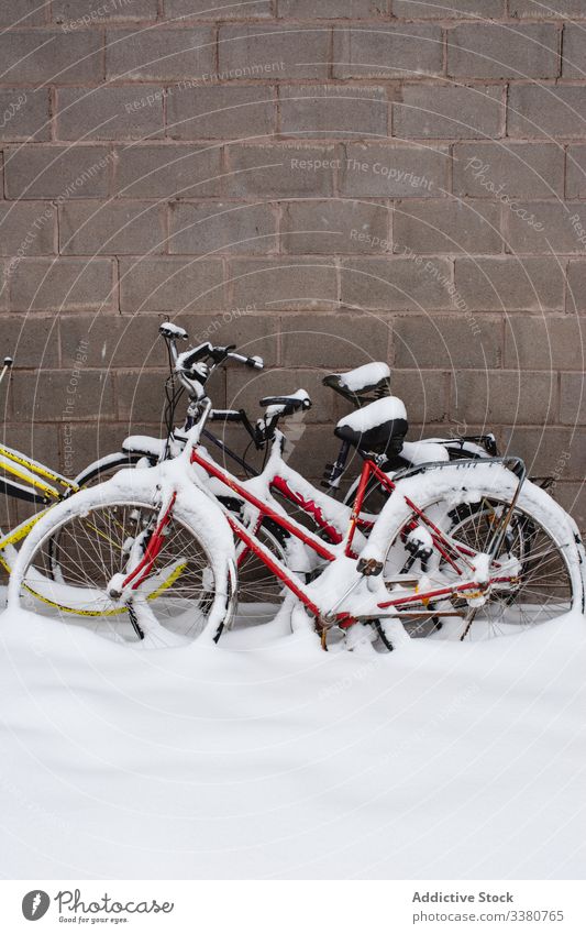 Covered with snow bicycles next to stone wall winter bike street transport colorful vehicle travel exterior building tourism swedish lapland norrbotten north