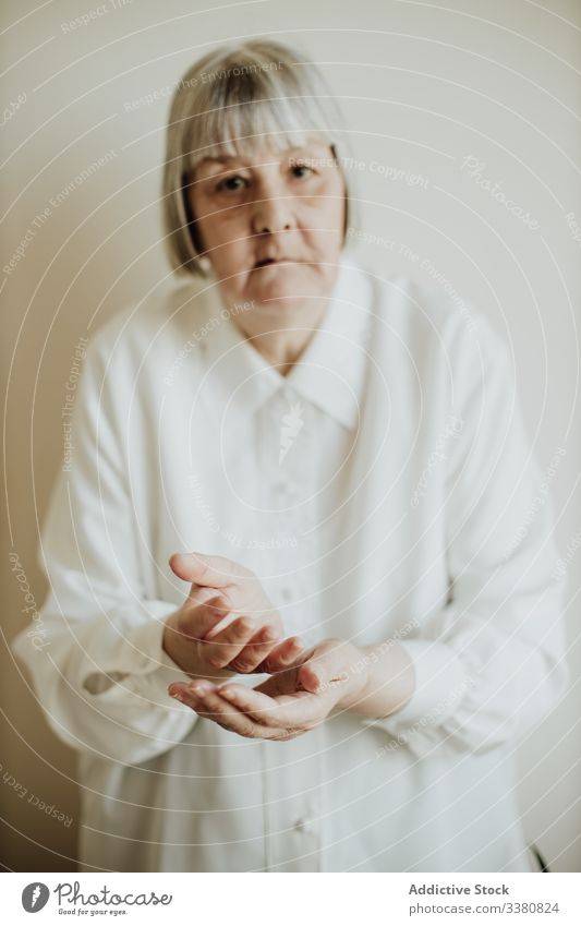 Old woman gesturing in studio old gesture elderly show rise hands senior home female pensioner serious natural blouse contemporary sign event festive