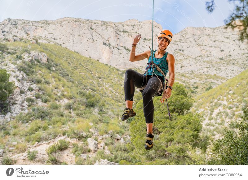 Happy young female climber enjoying mountaineering woman alpinist hang cliff ascend terrain adventure extreme risk active challenge adrenalin freedom altitude