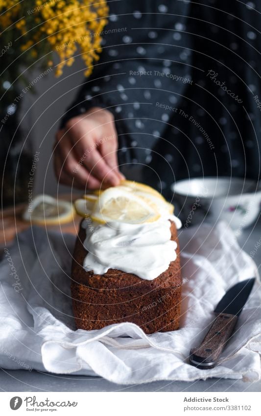 Housewife decorating cake with sliced lemon homemade decorate hand woman food bake pastry citrus icing tasty cuisine yummy prepare female fresh sweet dessert