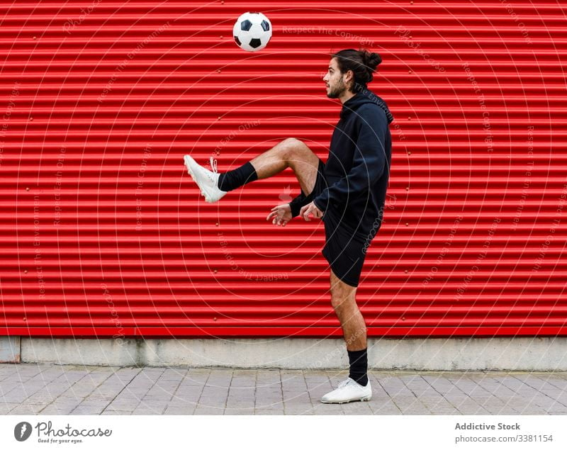 Man playing soccer ball on street man training feint kick football sport activity game male energy urban motion healthy lifestyle guy sportsman summer