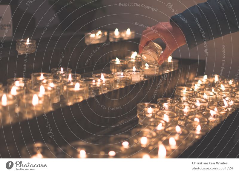 Woman lighting a candle at a candle altar Human being Feminine Adults Hand 1 30 - 45 years 45 - 60 years shoulder stand Candlelight Candlelit ambience