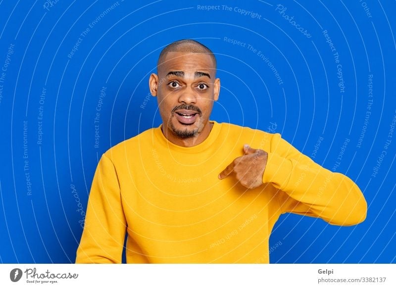 African guy with a yellow jersey black blue point indicate myself me select indicating finger selection advertisement copy space hand sign choose adult people