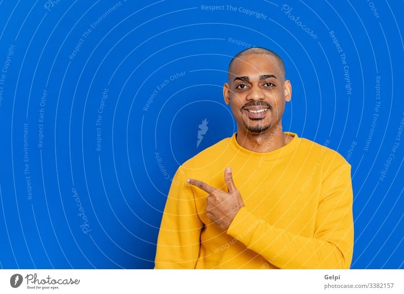 African guy with a yellow jersey black blue point indicate indicating finger advertisement adult people person african male american man isolated background