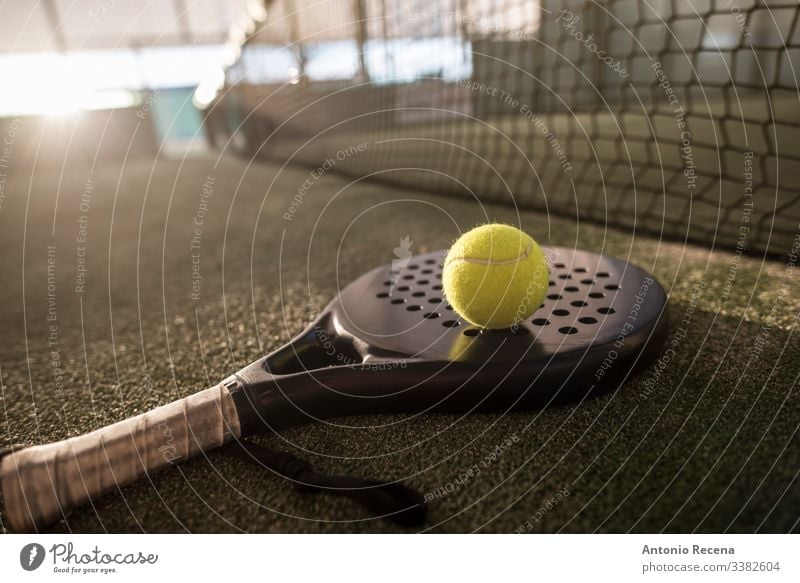 Paddle tennis racket and ball in sunset image padel paddle tennis sport paddle-tennis pádel court net tennis ball outdoors objects no people nobody fences turf