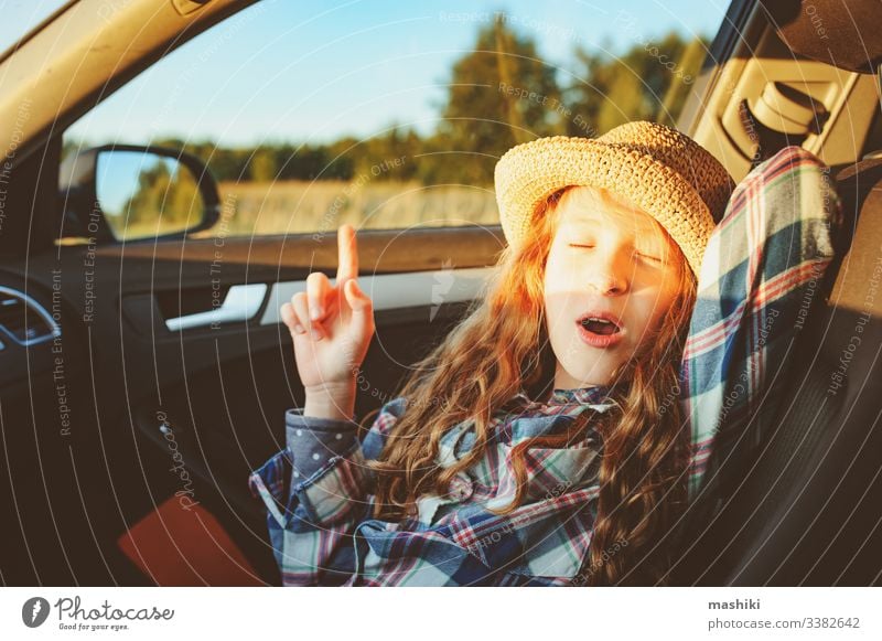 happy child girl relaxing in car during summer road trip. Exploring new places, traveling on summer vacations. nature outdoor auto drive freedom lifestyle fun