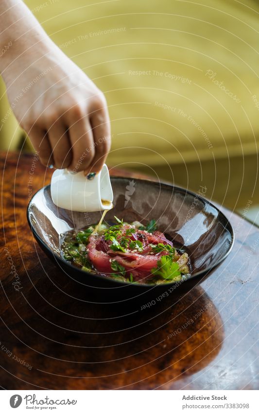 Person pouring sauce into salad in plate vegetable cook prepare serve fresh tasty delicious cuisine gourmet ingredient gastronomy chef green recipe garnish