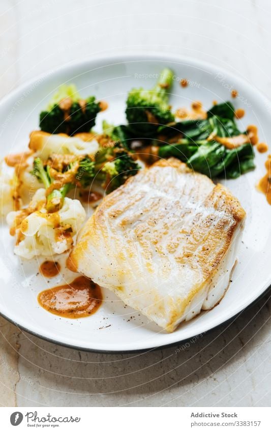 Fish with vegetables and sauce on plate fish broccoli green food fresh gourmet delicious tasty cuisine dish healthy ingredient portion culinary serve appetizing