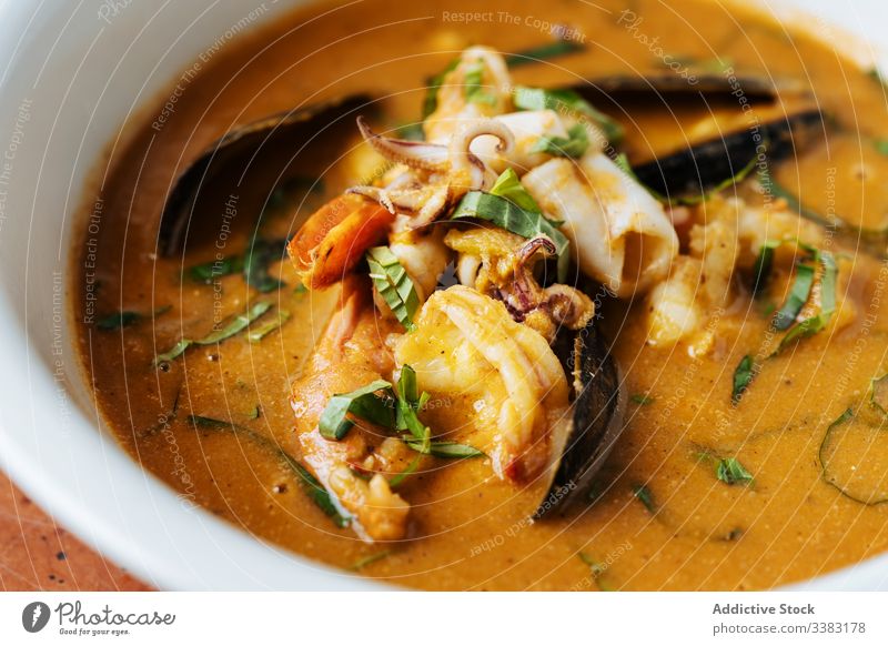 Seafood ragout served with herbs in restaurant seafood sauce high cuisine mussels octopus meat colorful bowl plate culinary orange dish gourmet fresh delicious