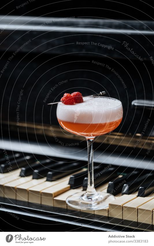 Perfect Clover Club cocktail on piano keys drink beverage raspberry red foam glass decor alcohol clover club gin style pub luxury celebrate mix portion juice