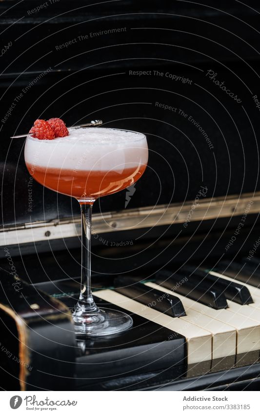 Perfect Clover Club cocktail on piano keys drink beverage raspberry red foam glass decor alcohol clover club gin style pub luxury celebrate mix portion juice