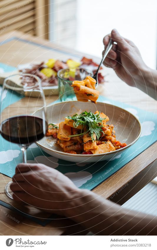 Anonymous person eating classic Italian pasta italian dish haute cuisine restaurant vegetable slice piece tomato sauce bowl fresh serve tradition organic