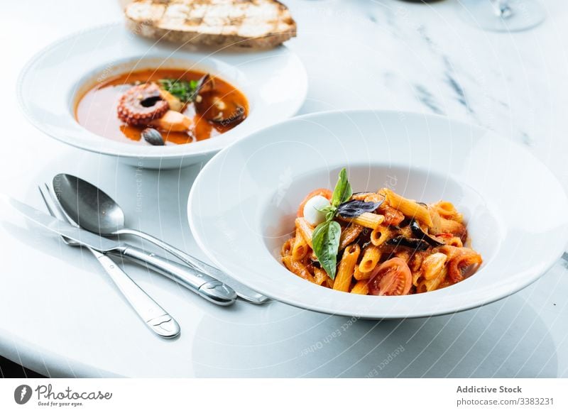 Plate with classic Italian pasta in restaurant italian dish haute cuisine vegetable slice piece tomato eggplant sauce basil noodle bowl fresh serve tradition