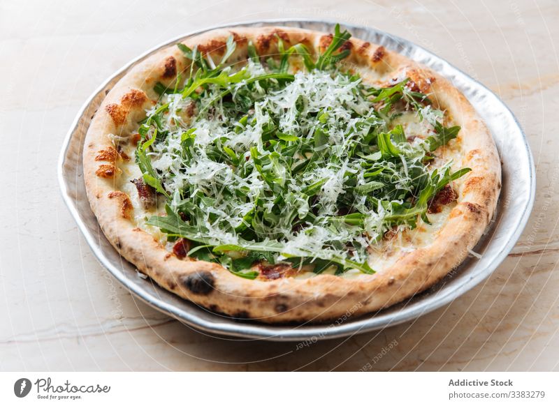 Fresh pizza with arugula in restaurant greenery cheese herb bake dough pastry italian food meal tasty fresh dinner dish snack prepare round rustic culinary