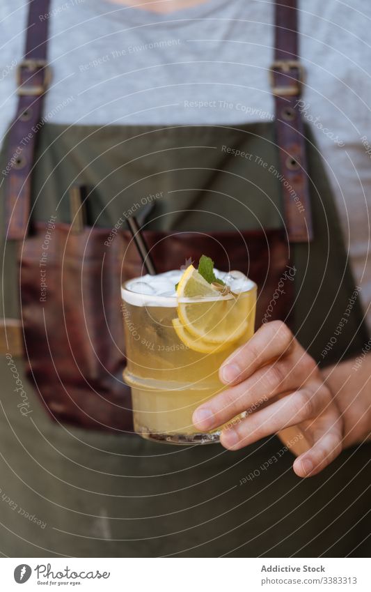 Person with glass of cocktail decorated with sliced lemon and mint lemonade drink beverage delicious tasty fresh cold juice straw relax fruit refreshment exotic