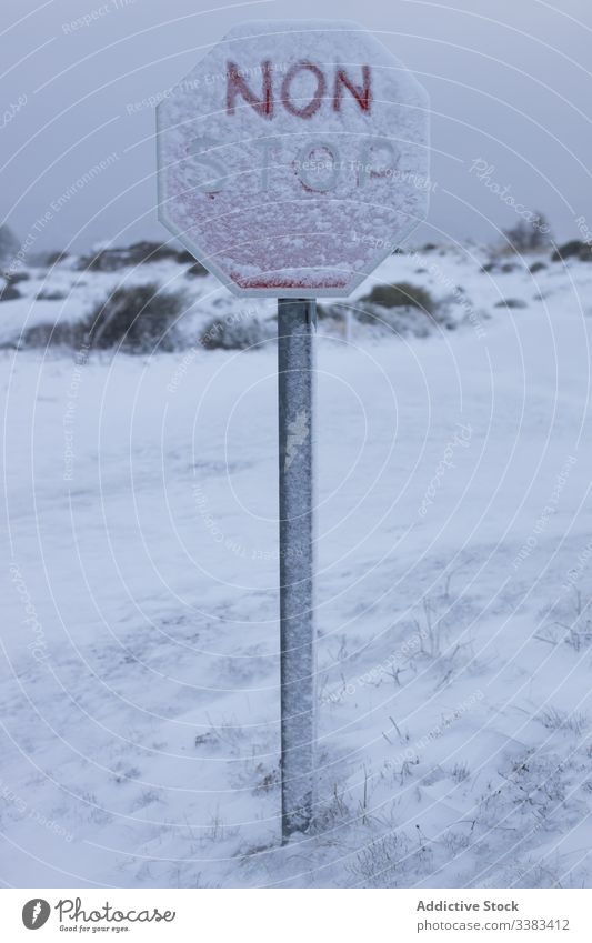 Stop sign in snow on cold remote hill road sign stop terrain blizzard sky winter nature symbol post rural environment tourism warning gray destination trip