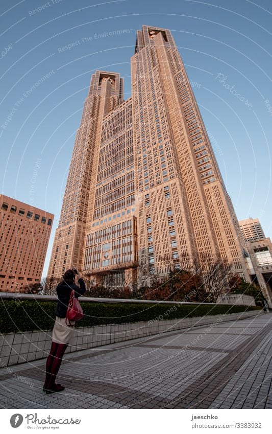 Young woman photographs high-rise in Japan High-rise Architecture Tokyo City hall skyscrapers Tourism sightseeing walk Tall House (Residential Structure)