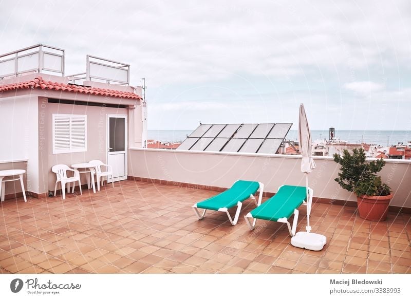 Rooftop with sunbeds on a cloudy day. summer city roof vacation relax retro sky lifestyle sunbathing deck chair clouds terrace view travel town architecture