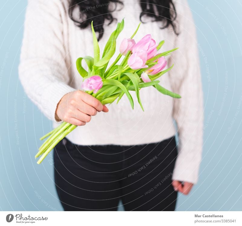 Woman in a white sweater with a bouquet of pink tulips. Spring concept. mother love romantic valentine glamour greeting present wedding horizontal styling