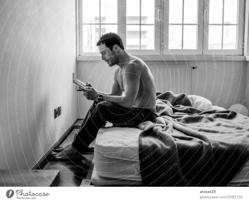 Man reading in his bedroom in black and white relaxing learn knowledge young man lying home male handsome book lifestyle person adult morning caucasian happy