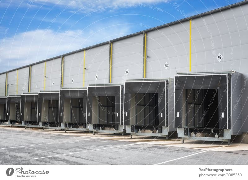 Industrial warehouse loading docks. Warehouse doors. Open gates access doors blue sky building business cargo storehouse delivery distribution empty entrance