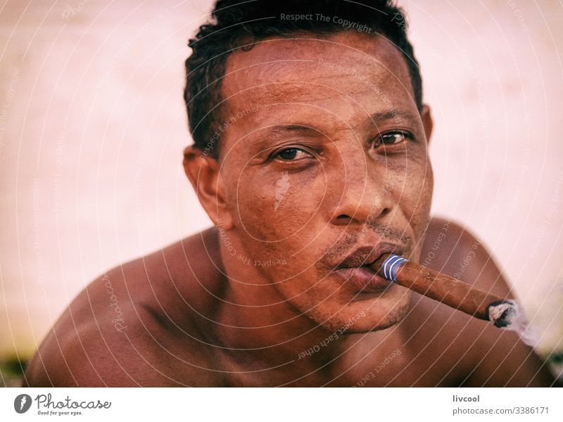man smoking , trinidad - cuba cigar adult smoke smile naked chest resting native cuban adulthood cute leather skin people portrait caribbean island street