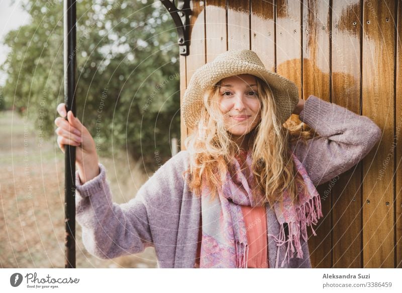 Young woman in straw hat traveling by retro wooden train. Sunset landscape, wind in blond hair. Girl smiling happily. Majorca, Spain. adventure beautiful