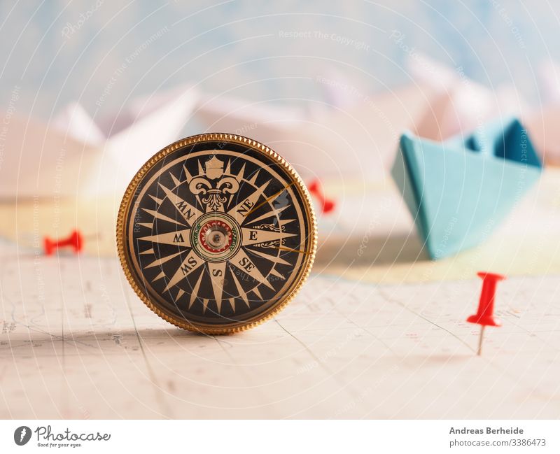 Close up of a compass and location marking with a red pin on sea map. abstract adventure ancient antique antiquity background burnt business century closeup