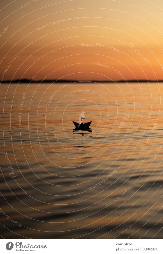 Paper ship at sunset on a lake voyage vacation travel Paper boat Healthy Alternative medicine Wellness Well-being Calm Leisure and hobbies Playing Handicraft
