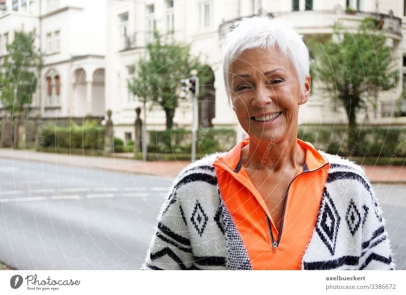 happy mature woman on street senior lady smile outside adult smiling city urban best ager 60 trendy sporty short white hair confident modern sixties cheerful