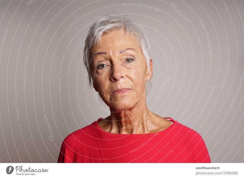mature woman with her head held high serious senior lady adult 60 sixties older person confident raised unsmiling female people elderly grey gray portrait