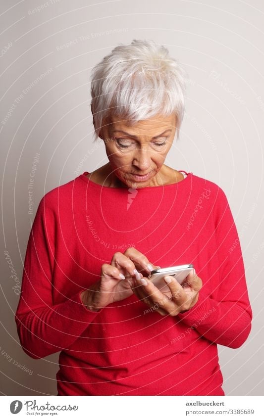 confused senior woman using smartphone mature lady mobile cell smart phone old-timer adult confusion granny grandmother looking at modern technology typing