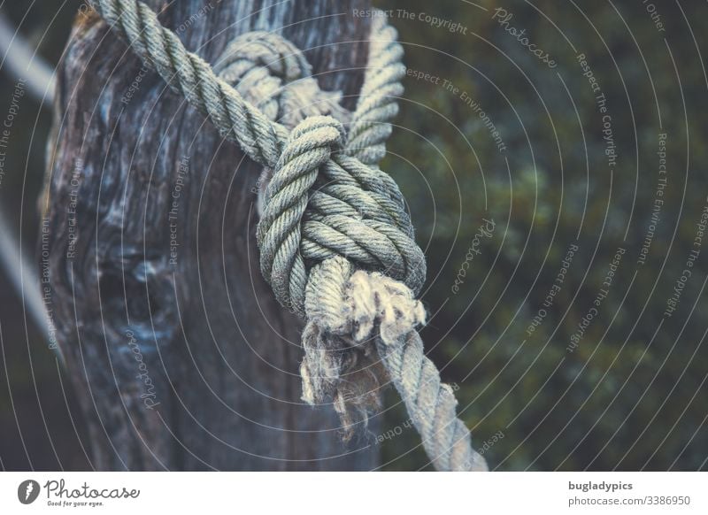 Thick rope tied around a fence post - a Royalty Free Stock Photo