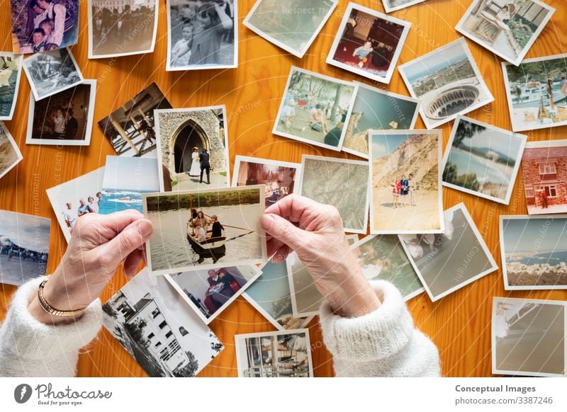 Top view of a senior caucasian woman looking at an old photos themes of memories nostalgia photos retired picture elderly wife together pensioner family