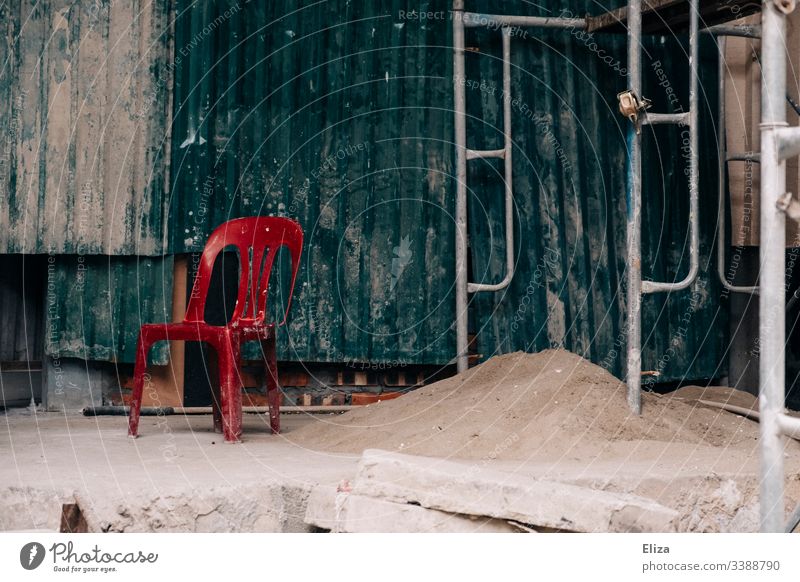 Red chair on a construction site Construction site Chair Sit Break Executive chair Work and employment Empty nobody sluggish Contrast Scaffolding Places