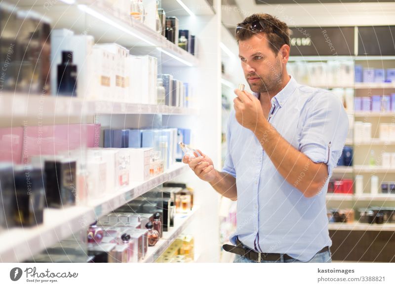 Elegant man choosing perfume in retail store. customer shop shopping beauty guy cosmetic person attractive male drugstore holding buy consumerism clients