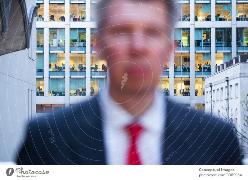 Defocussed businessman looking at the camera at dusk adult adults only business person city city life commuter corporate business day defocussed departure