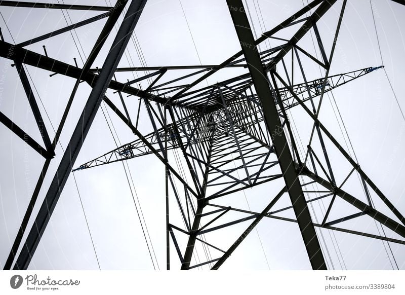 an electricity pylon from below horizontal energy cable Electricity pylon high voltage energy tranportation ampstorm sun lightning power plant power cable